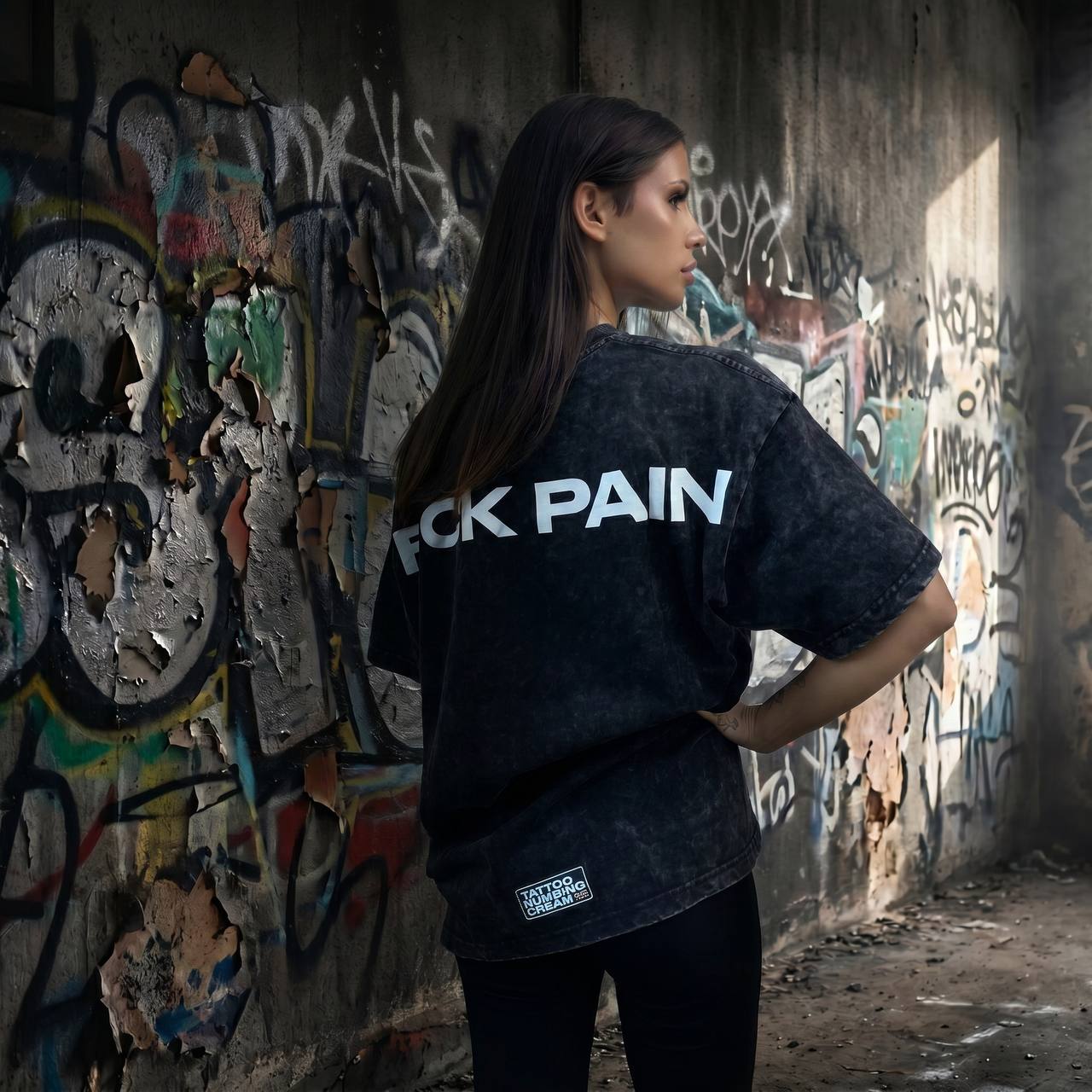 F*CK PAIN Acid Wash Oversized Tee — female lifestyle back shot graffiti wall